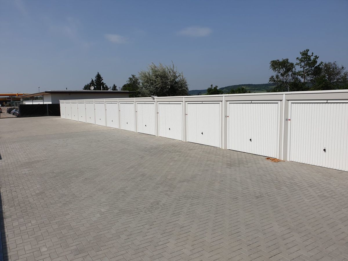 Lange Garagenzeile mit gepflastertem Hof